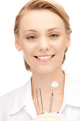 Image showing attractive female dentist with tools