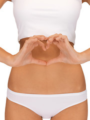 Image showing woman forming heart shape on belly