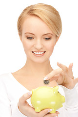 Image showing lovely woman with piggy bank and money