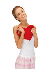 Image showing happy and smiling woman with heart-shaped pillow