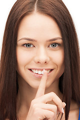 Image showing happy woman with finger on lips