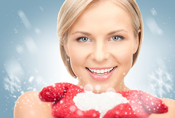 Image showing beautiful woman in red mittens with snow