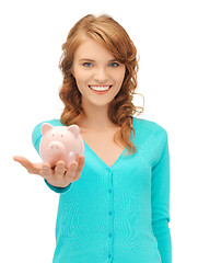 Image showing teenage girl with piggy bank