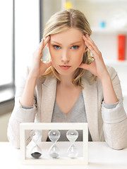 Image showing pensive businesswoman with sand glass