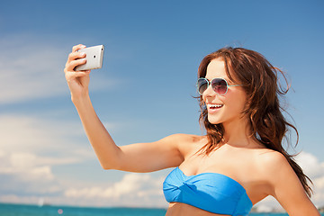 Image showing happy woman with phone on the beach