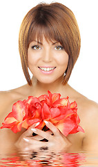 Image showing lovely woman with red flowers in water