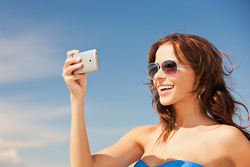 Image showing happy woman with phone on the beach