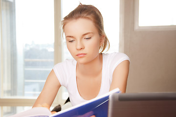 Image showing calm and serious teenage girl with big notepad