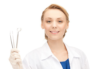 Image showing attractive female dentist with tools