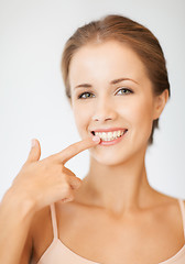 Image showing beautiful woman pointing to teeth