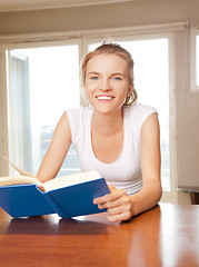 Image showing happy and smiling teenage girl with book