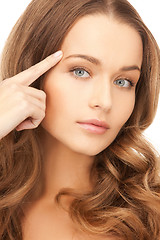 Image showing beautiful woman pointing to forehead