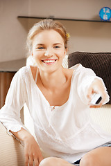 Image showing happy teenage girl with TV remote