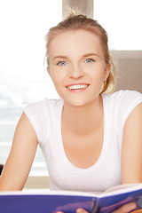 Image showing happy and smiling teenage girl with big notepad