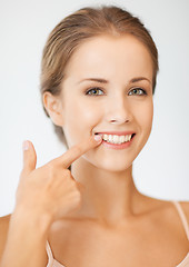 Image showing beautiful woman pointing to teeth