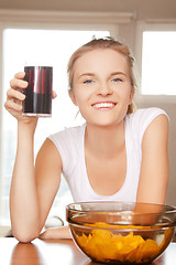 Image showing smiling teenage girl with chips and coke