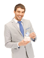 Image showing handsome man with piggy bank and money