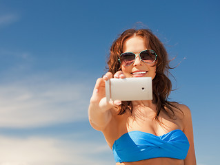 Image showing happy woman with phone on the beach