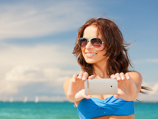 Image showing happy woman with phone on the beach