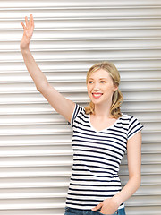 Image showing happy teenage girl waving a greeting