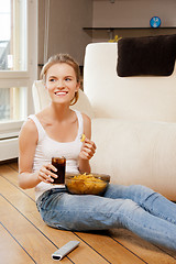 Image showing smiling teenage girl with remote control