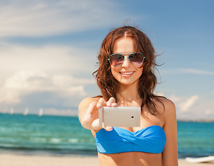 Image showing happy woman with phone on the beach