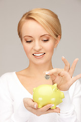 Image showing lovely woman with piggy bank and money