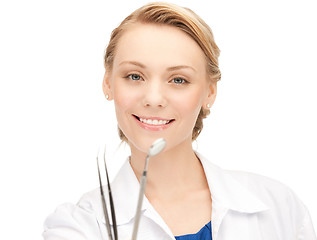 Image showing attractive female dentist with tools