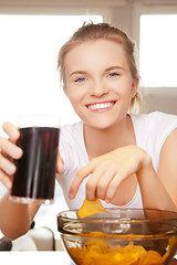 Image showing smiling teenage girl with chips and coke