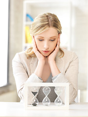 Image showing pensive businesswoman with sand glass