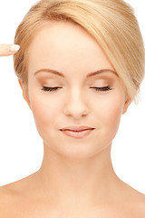 Image showing beautiful woman pointing to forehead