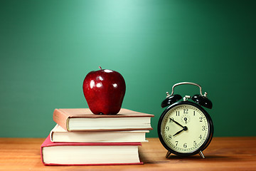 Image showing School Books, Apple and Clock on Desk at School