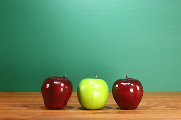 Image showing School Apples Sitting on Teacher Desk in a Row