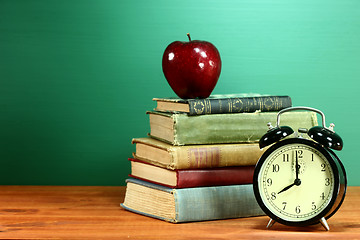 Image showing School Books, Apple and Clock on Desk at School