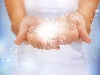 Image showing magic twinkles on female hands