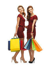 Image showing teenage girls in red dresses with shopping bags