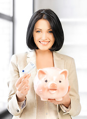 Image showing lovely woman with piggy bank and money