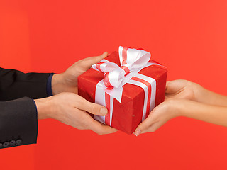 Image showing man and woman's hands with gift box