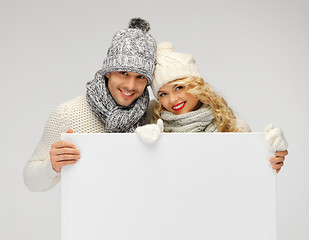 Image showing couple in a winter clothes holding blank board