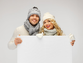 Image showing couple in a winter clothes holding blank board