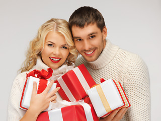 Image showing romantic couple in a sweaters with gift boxes