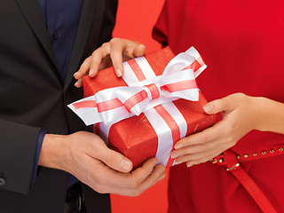 Image showing man and woman's hands with gift box