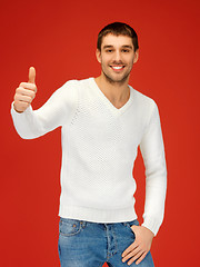 Image showing man in warm sweater showing thumbs up