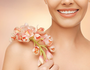 Image showing woman's shoulder and hands holding orchid flower