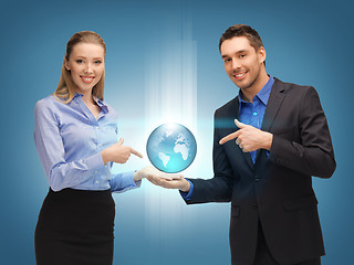 Image showing man and woman showing earth globe on the palms
