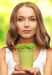 Image showing woman with green grass in pot