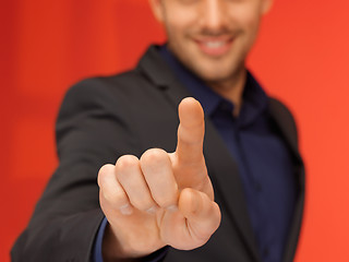 Image showing handsome man in suit pressing virtual button