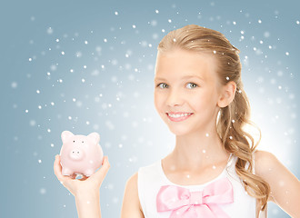 Image showing lovely teenage girl with piggy bank