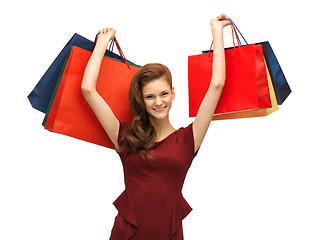 Image showing teenage girl in red dress with shopping bags