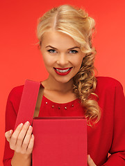 Image showing lovely woman in red dress with opened gift box